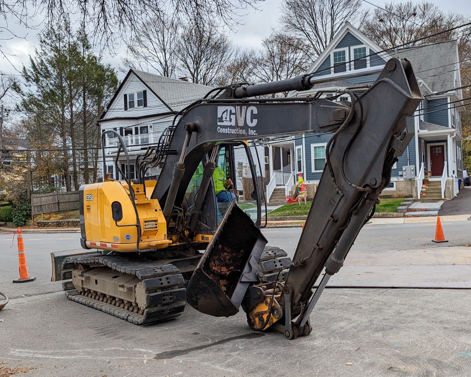 Tracked excavator working on a residential street in Massachusetts